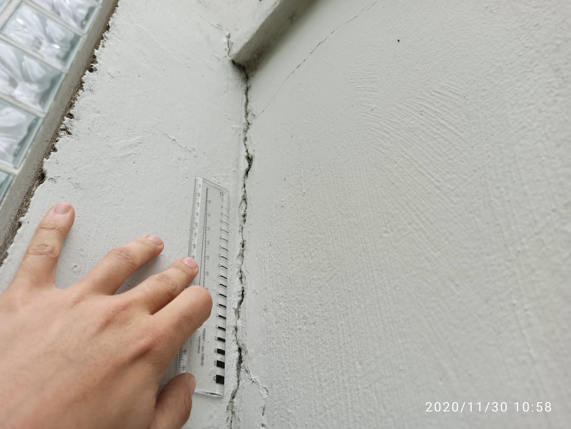 Detalhe da medição da abertura de uma fissura em milímetros com fissurômetro