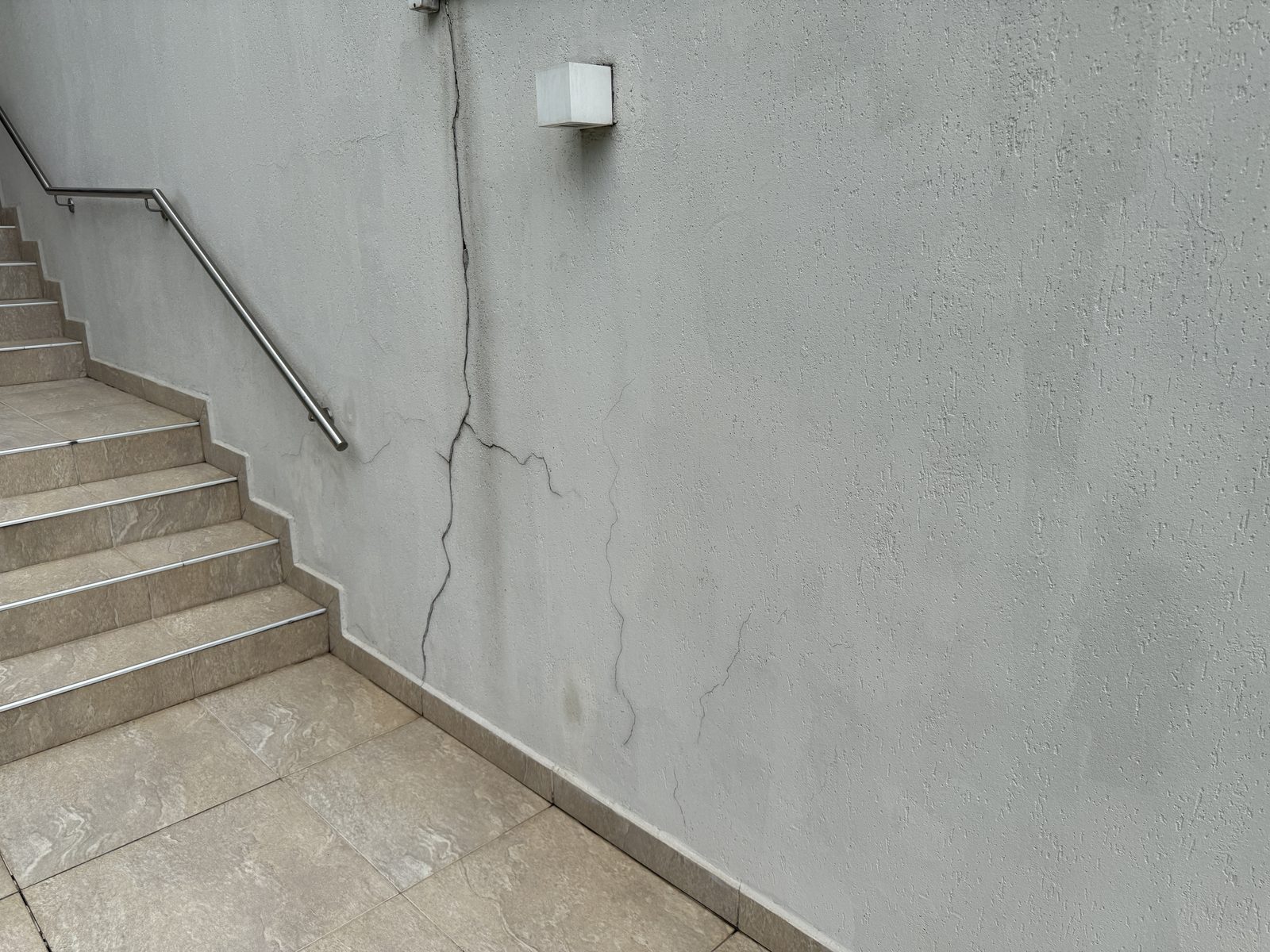 Fissuras no muro lateral de divisa com o terreno da obra
