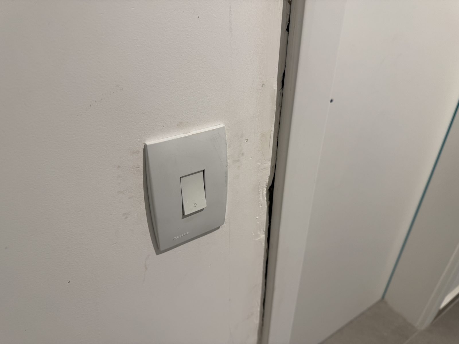 Falha de acabamento na parede junto à porta de entrada de apartamento novo
